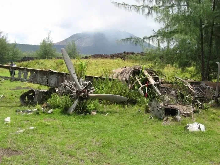 Wreckage of a World War II aircraft in grassland on a volcanic island in the Northern Mariana Islands